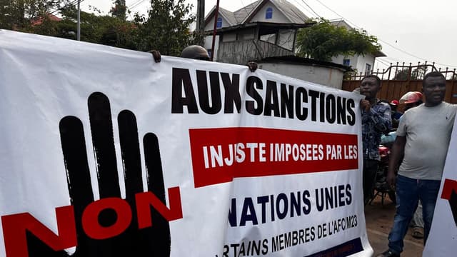 Des manifestants déploient dans une rue de Goma une grande banderole portant un symbole de main et le mot « NON » en rouge, avec l'inscription « Aux sanctions injustes imposées par les Nations unies à certains membres de l'AFC/M23 ».