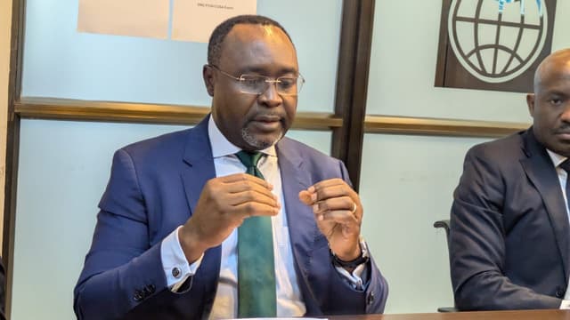 Albert Zeufack, directeur des opérations de la Banque mondiale pour la RDC, s'exprime assis derrière une table lors d'un café de presse à Kinshasa, devant le logo de la Banque mondiale