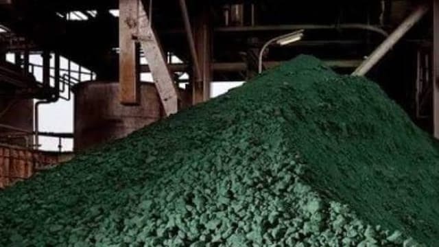 Un immense tas d'hydroxyde de cobalt vert entassé sous les passerelles métalliques d'une usine de traitement minier en République démocratique du Congo