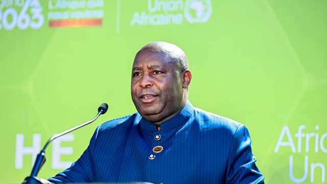 Le président burundais Évariste Ndayishimiye s'exprime au pupitre devant un décor de l'Union africaine lors du sommet d'Accra