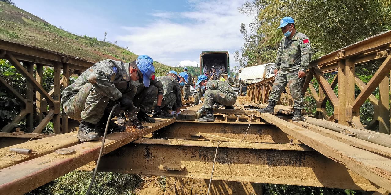 Des ouvriers et des engins reparent un pont routier en Republique democratique du Congo.