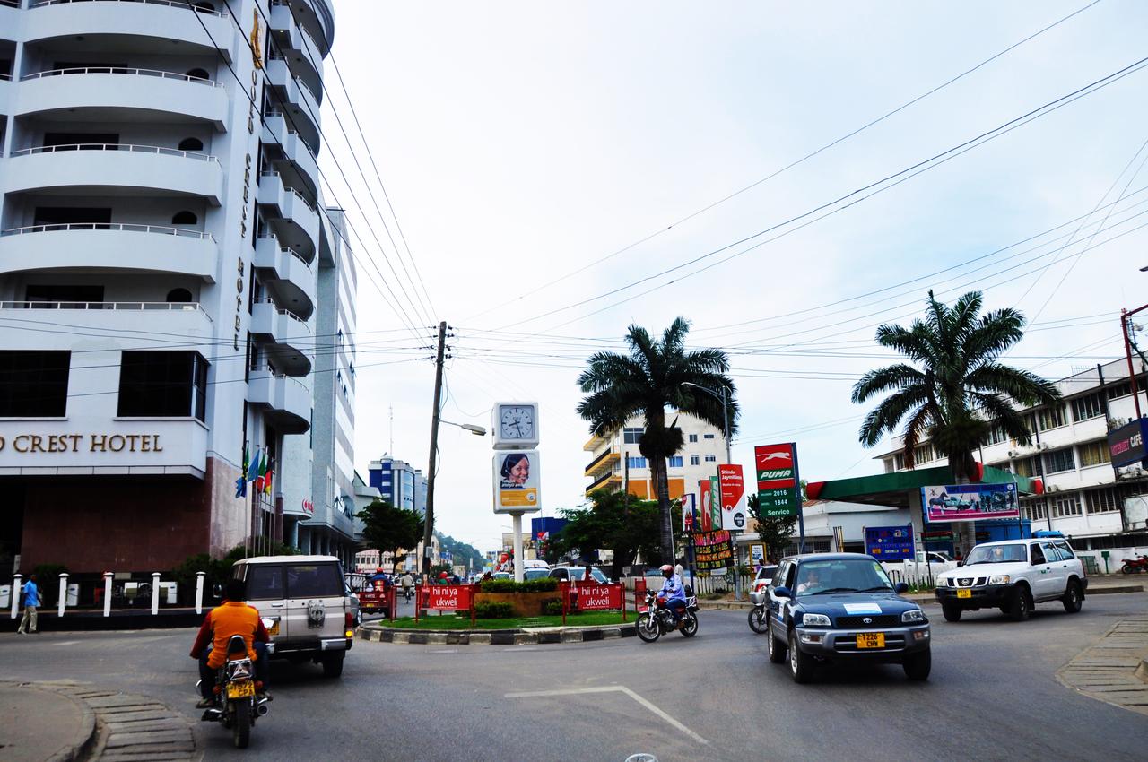 Rue commerçante du centre-ville de Mwanza, en Tanzanie, bordée d'immeubles et de boutiques, avec des piétons et des véhicules.