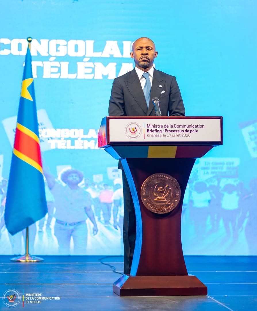 Patrick Muyaya, ministre de la Communication et porte-parole du gouvernement congolais, debout derrière un pupitre portant la mention « Briefing - Processus de paix, Kinshasa, le 17 juillet 2026 », à côté du drapeau de la RDC