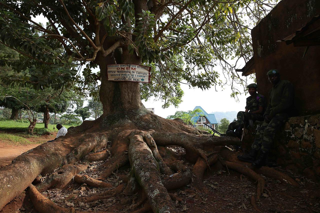 Deux militaires des FARDC en tenue de camouflage montent la garde, arme à la main, devant un bâtiment administratif de la ville de Beni, au Nord-Kivu.