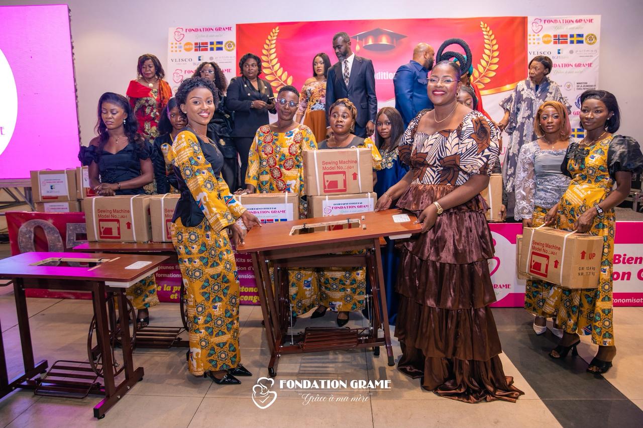 Des jeunes femmes formées par la Fondation GRAME posent avec leurs kits d'installation , machines à coudre et matériel de métier , lors de la cérémonie de remise à Kinshasa.
