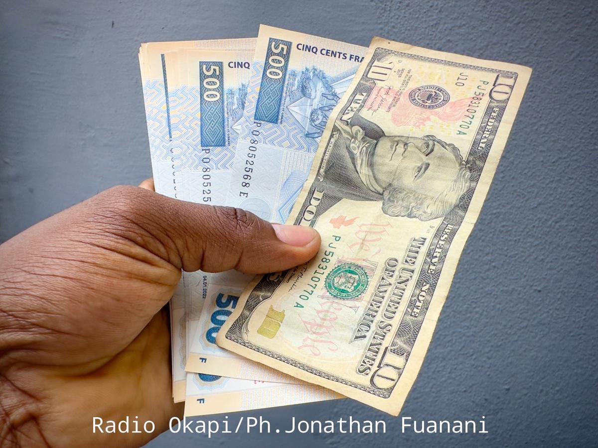 Des billets de francs congolais étalés autour d'un billet de dix dollars américains