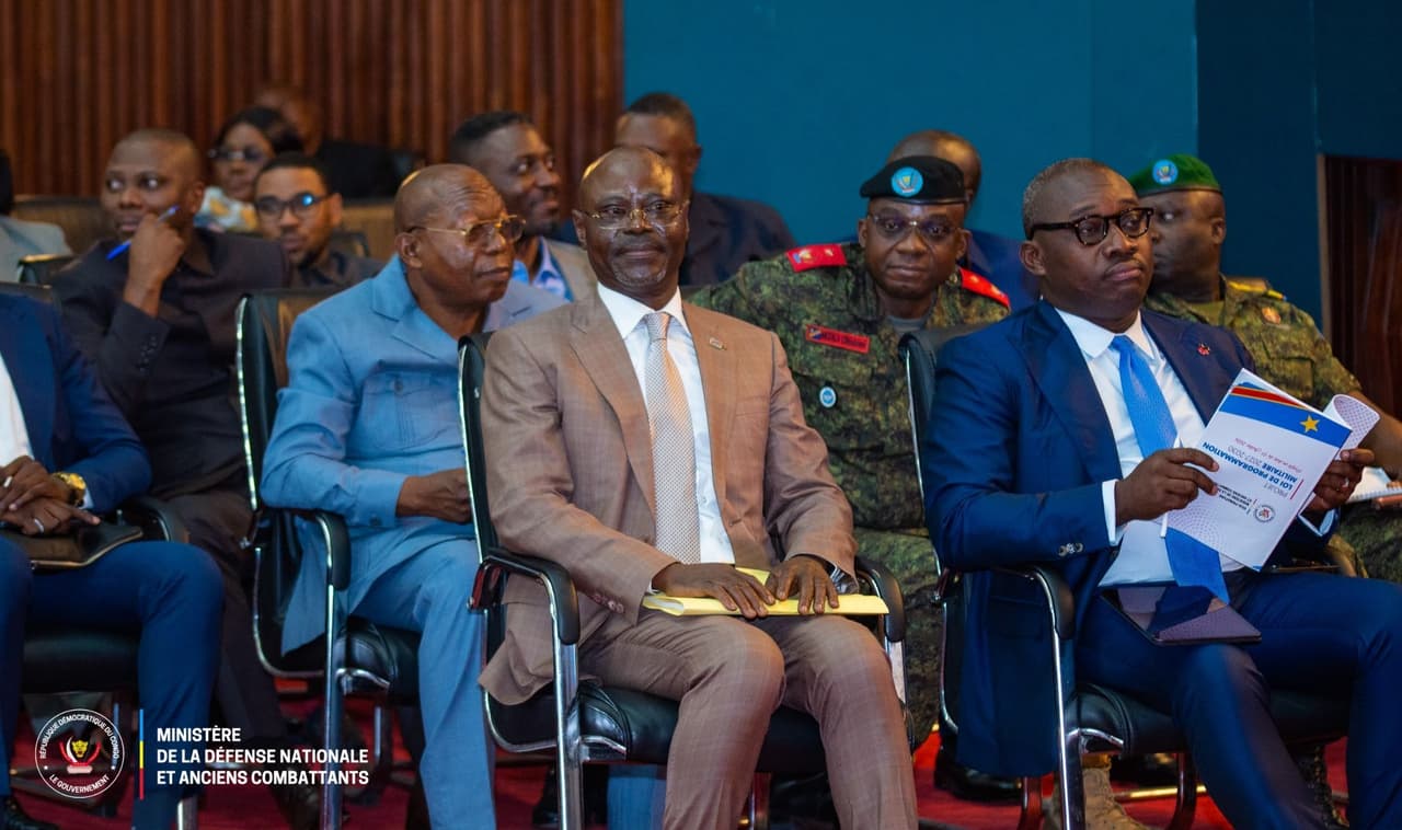 Des responsables civils et des officiers des FARDC assis lors de la présentation du projet de loi de programmation militaire 2027-2030, dont un exemplaire est tenu en main au premier rang.