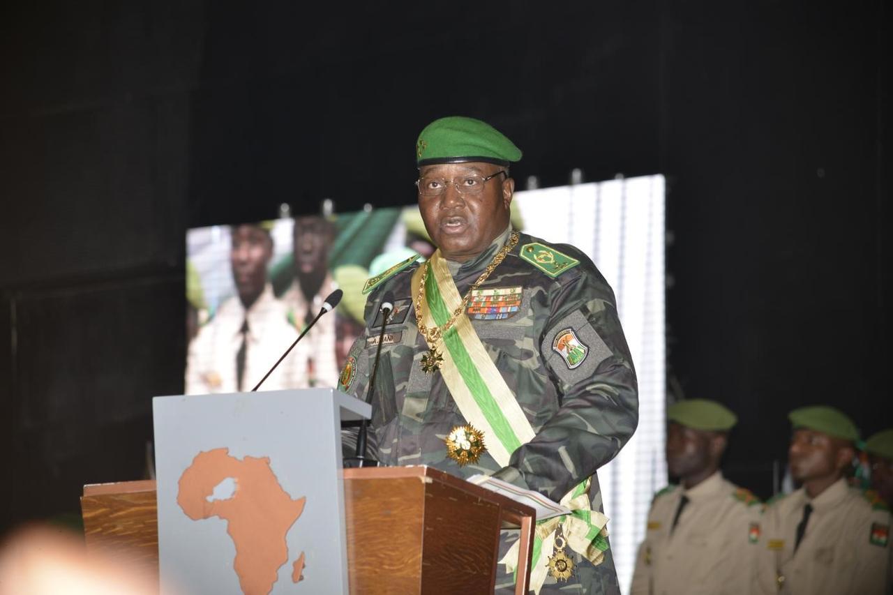 Le général Abdourahamane Tiani, en tenue militaire avec béret vert et écharpe présidentielle, prononce un discours à une tribune lors d'une cérémonie officielle